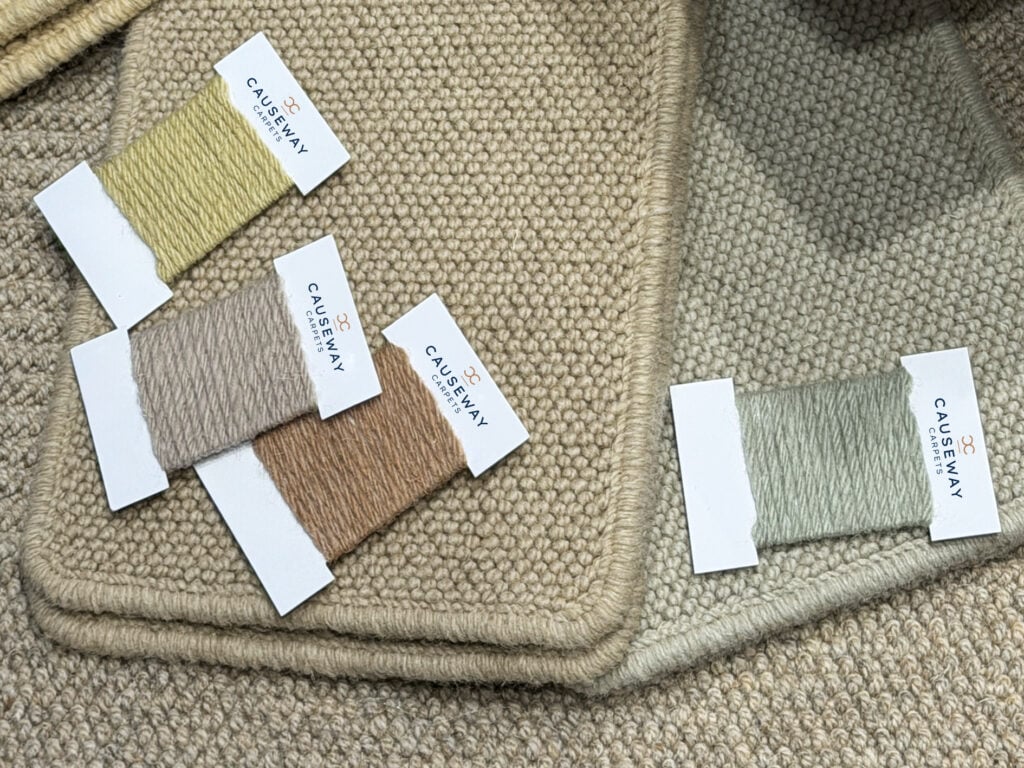 Causeway Carpets wool samples in natural green and earth tones, reflecting sustainable flooring trends and modern interior colour palettes.