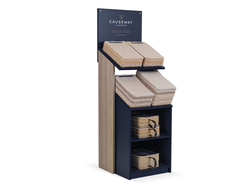Compact carpet sample display stand with stacked beige swatches and branded signage.