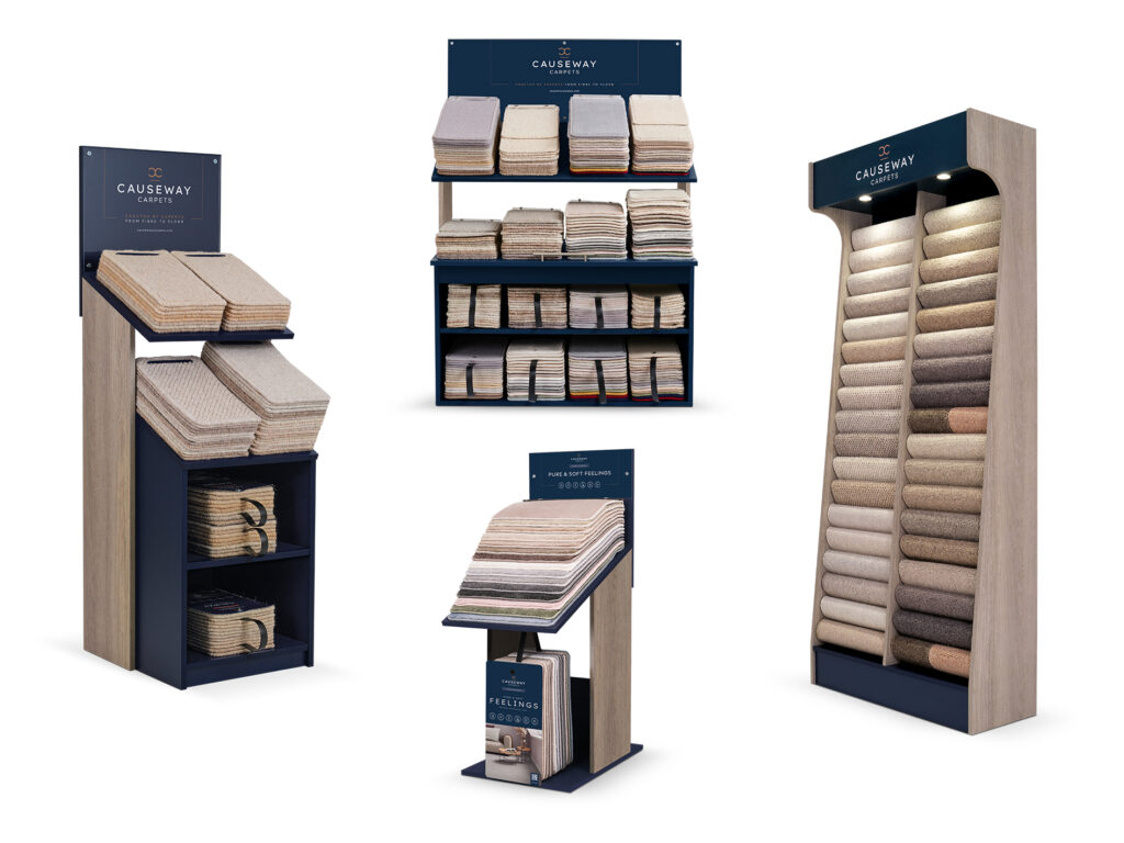 Collection of carpet sample display units featuring stacked swatches, hanging samples, and illuminated rolls with Causeway Carpets branding.