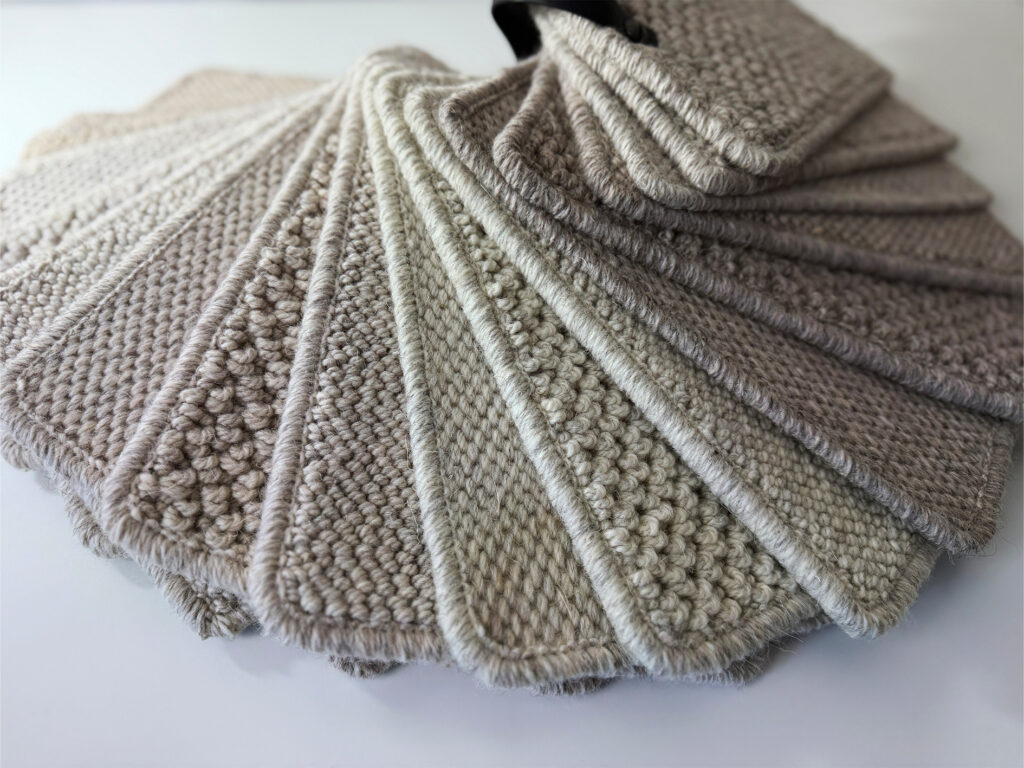 Close-up of Natural Coordinates Weave and Knot wool carpet samples in soft neutral shades, showing textured weave and loop pile finishes