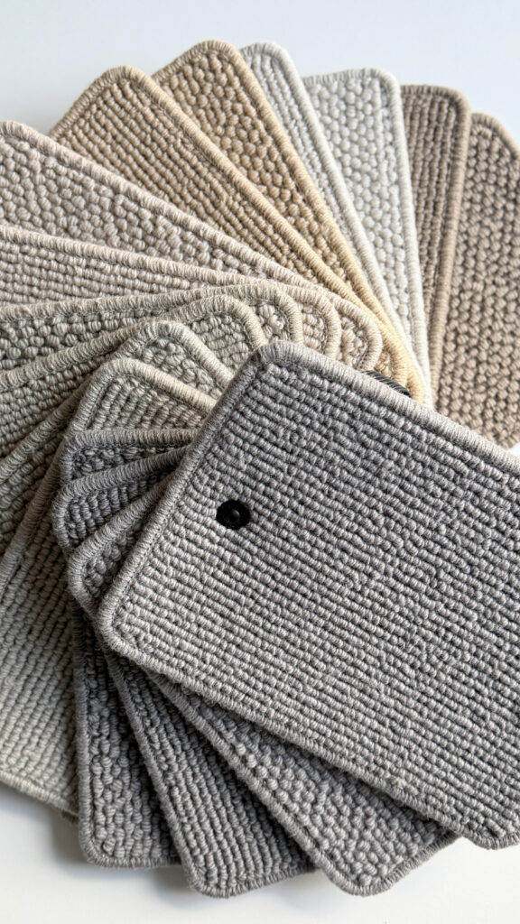 Luxury wool carpet samples in elegant neutral tones featuring textured loop and woven pile finishes, showcasing premium bespoke carpeting for high-end interior design, luxury homes, boutique hotels and contemporary living spaces.