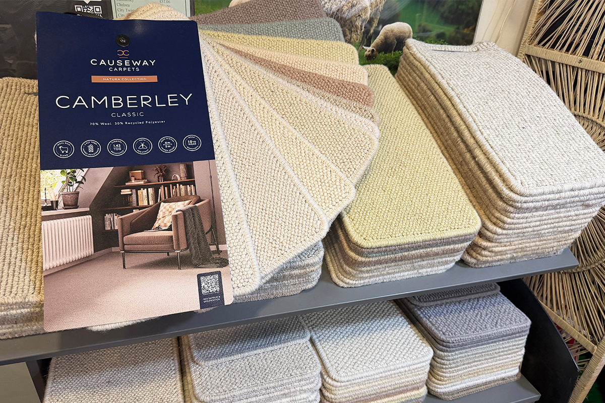Causeway Carpets Camberley Classic wool carpet sample display featuring a range of neutral loop-pile carpet swatches in a retail showroom.