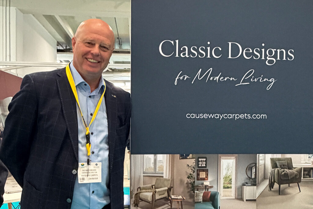 Richard Moore, Commercial Director at Causeway Carpets, beside a Causeway Carpets display at The Flooring Show Harrogate.